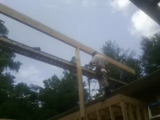 Carpenter setting a ridge beam over a new addition frame — Ice Dam Removal by Roofing Brothers in West Newbury