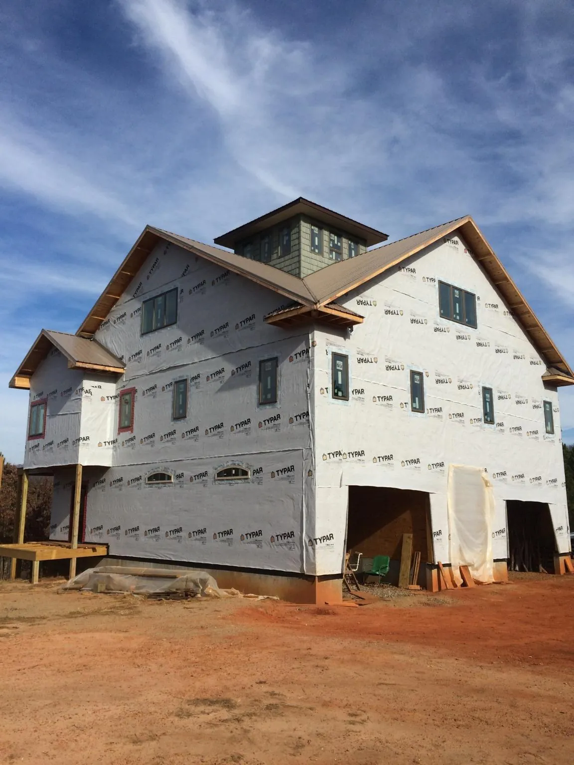 New two story house under construction with a cupola and gabled roofs in West Newbury